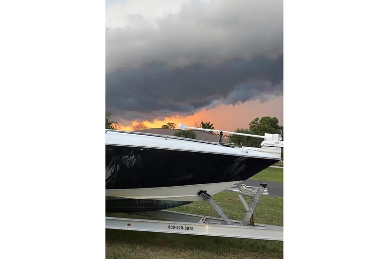 Slide: The Image of 2003 Sports Fisher 340 boat on trailer with dramatic cloudy sunset backdrop. - 2