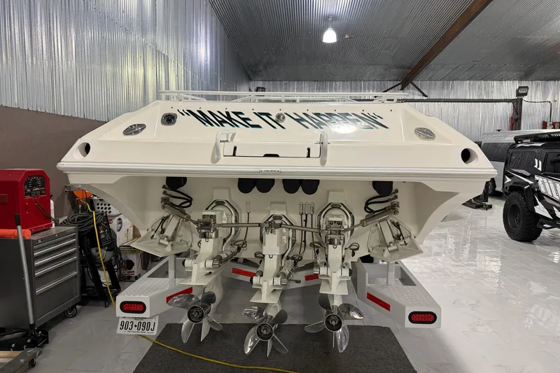 Slide: The Image of Rear view of a 2000 Fountain 47 Lightning boat in a garage setting. - 11