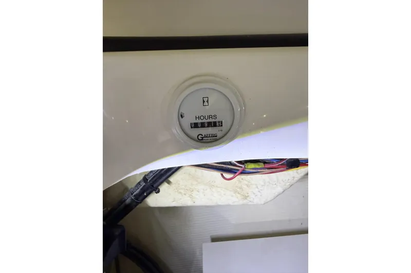 Slide: The Image of Hour meter on a 2000 Fountain 47 Lightning boat dashboard with visible wiring. - 4