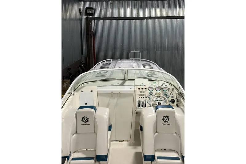 Slide: The Image of 2000 Fountain 47 Lightning boat interior with dashboard and seating in a metal-walled storage area. - 5