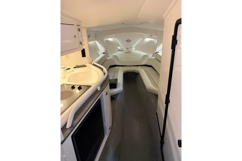 Slide: The Image of Interior of 2000 Fountain 47 Lightning boat with white seating and compact kitchenette. - 7