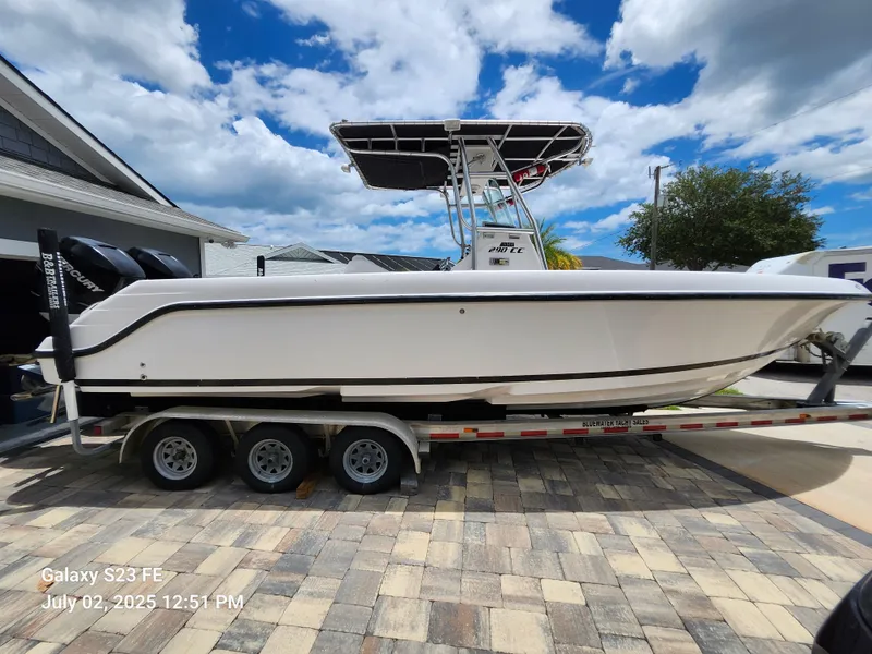 The Image of 2010 Donzi 29ZF boat on trailer, parked in driveway under blue sky. - 0