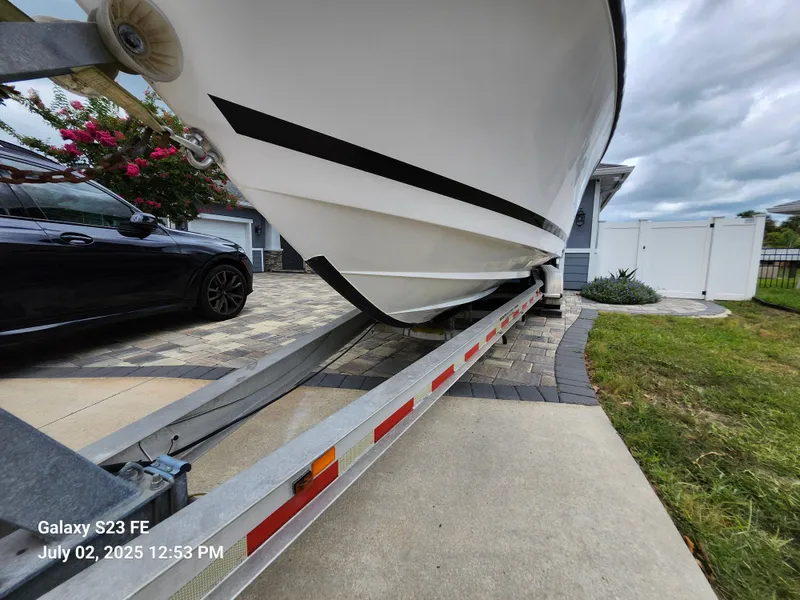 Slide: The Image of 2010 Donzi 29ZF boat on trailer in driveway, next to a black car. - 12