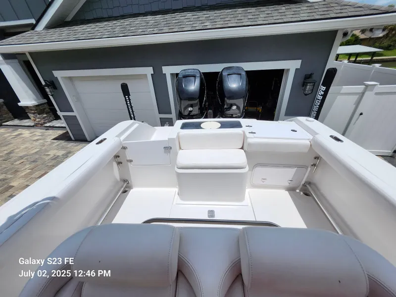 Slide: The Image of 2010 Donzi 29ZF boat interior with dual engines, parked near a garage. - 14