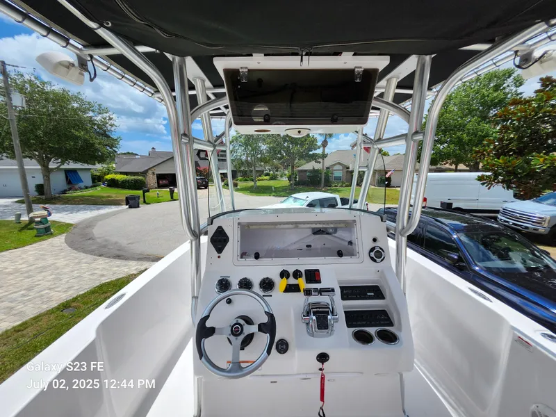 Slide: The Image of 2010 Donzi 29ZF boat dashboard with steering wheel and controls, parked in a residential area. - 18