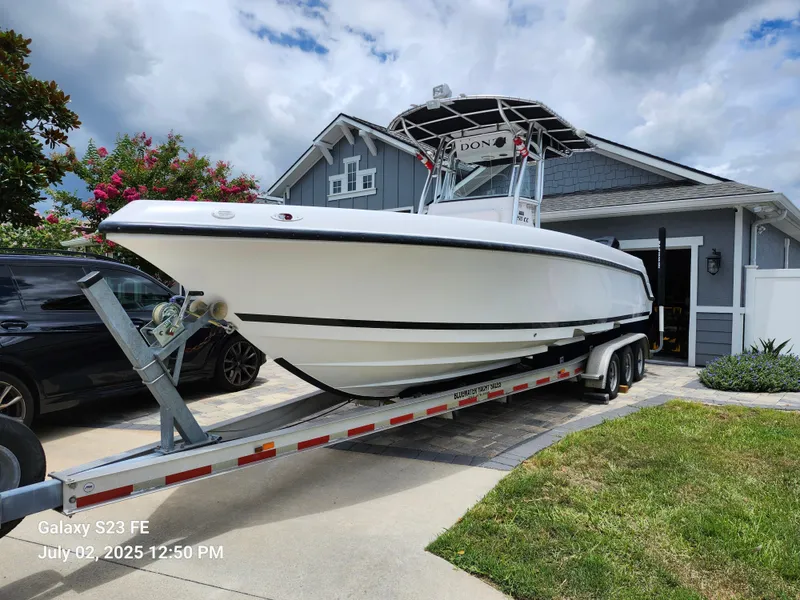 Slide: The Image of 2010 Donzi 29ZF boat on trailer in driveway, overcast sky. - 2