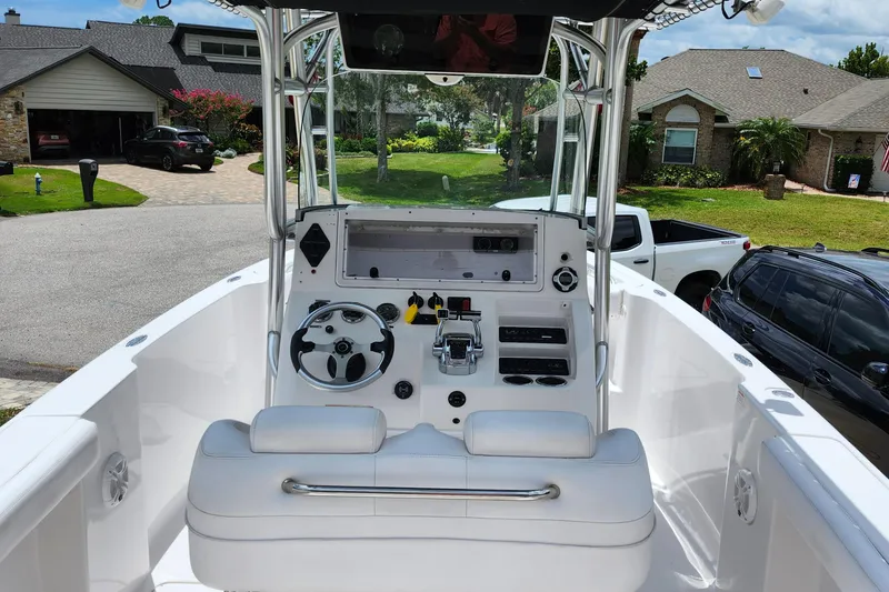 Slide: The Image of 2010 Donzi 29ZF boat cockpit with steering wheel, controls, and seating in a residential driveway. - 8