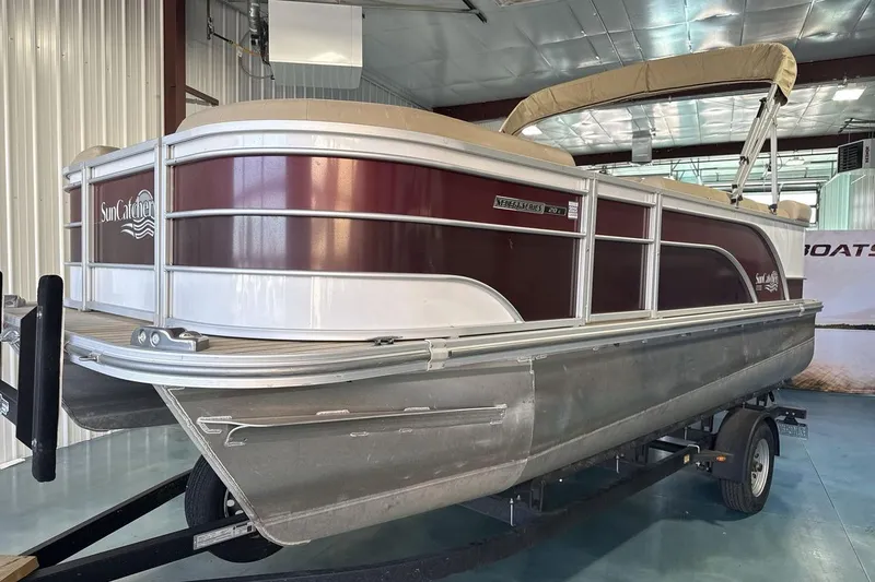 The Image of 2021 SunCatcher Select 20C pontoon boat in showroom, featuring maroon and white design. - 1