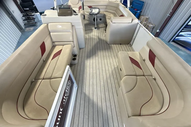 Slide: The Image of Interior of 2021 SunCatcher Select 20C pontoon boat with beige seating and wood flooring. - 12