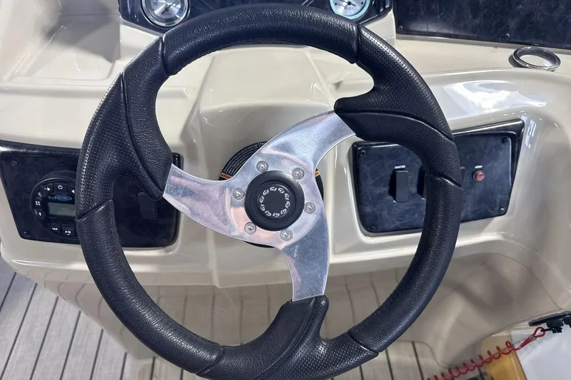 Slide: The Image of Steering wheel of 2021 SunCatcher Select 20C boat, featuring modern dashboard controls. - 14
