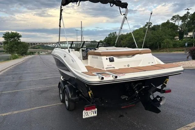 Slide: The Image of 2017 Searay SPX210 boat parked on a riverside lot, featuring sleek design and dual axles. - 13