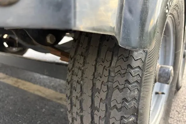 Slide: The Image of Close-up of a 2017 Searay SPX210 trailer tire on asphalt. - 21