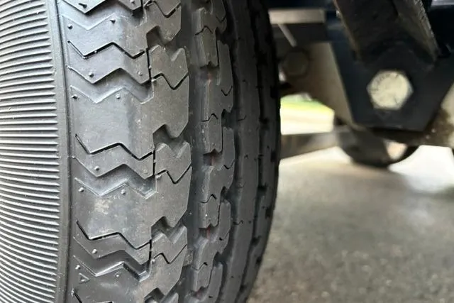 Slide: The Image of Close-up of a 2017 Searay SPX210 trailer tire on a wet surface. - 24