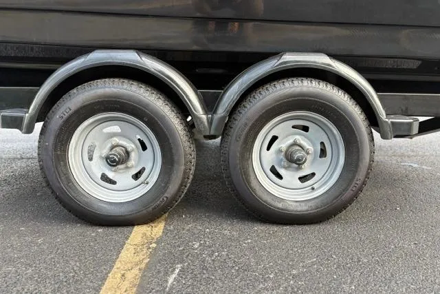 Slide: The Image of Trailer wheels of a 2017 Searay SPX210 boat on asphalt pavement. - 26