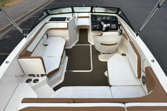 Slide: The Image of 2017 Searay SPX210 boat interior with brown and white seating, steering console, and spacious layout. - 29