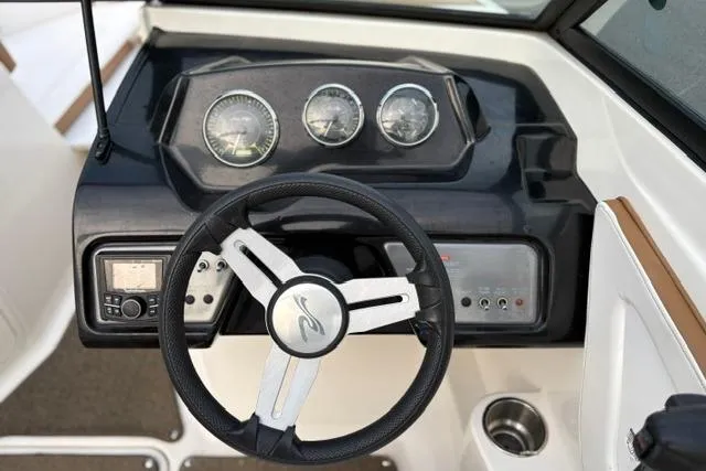 Slide: The Image of Steering wheel and dashboard of a 2017 Searay SPX210 boat, featuring gauges and controls. - 32