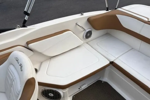Slide: The Image of 2017 Searay SPX210 boat interior with white and brown seating, featuring built-in speakers. - 36
