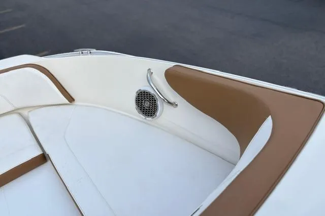 Slide: The Image of 2017 Searay SPX210 boat interior with white and brown seating and speaker detail. - 42