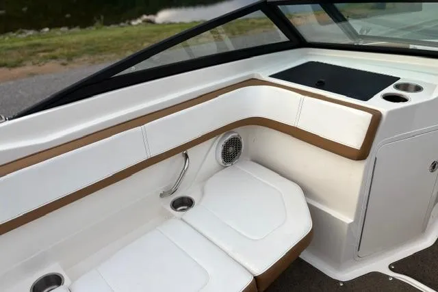 Slide: The Image of 2017 Searay SPX210 boat interior with white and tan seating, cup holders, and speaker. - 49