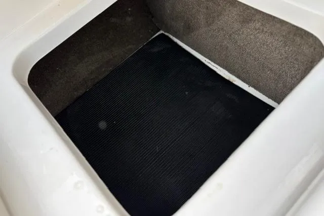 Slide: The Image of Storage compartment of a 2017 Searay SPX210 boat, featuring a black mat interior. - 52