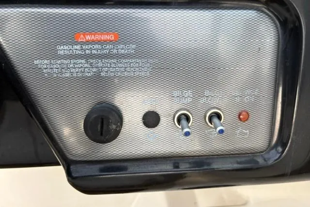 Slide: The Image of Control panel of a 2017 Searay SPX210 boat with warning label and switches. - 56