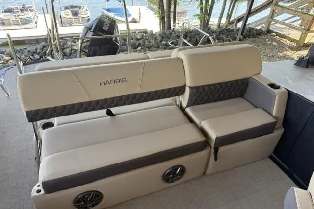 Slide: The Image of 2025 Harris Sunliner 230 boat interior with beige seating and lake view. - 10