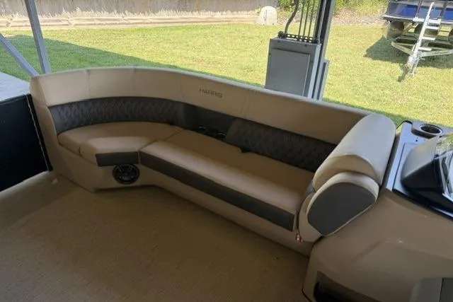 Slide: The Image of 2025 Harris Sunliner 230 boat interior with beige seating and modern design. - 12