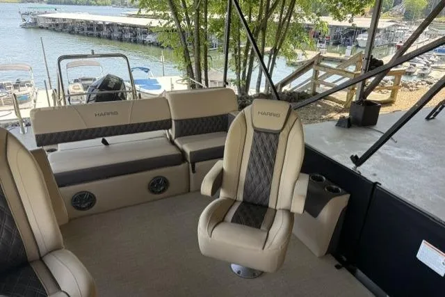 Slide: The Image of 2025 Harris Sunliner 230 pontoon boat interior with luxurious seating and lake view. - 13