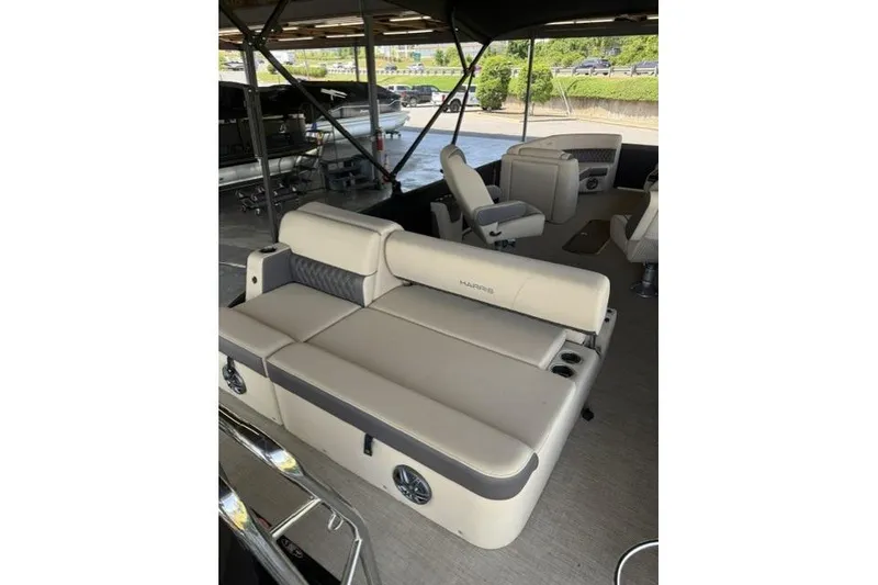 Slide: The Image of 2025 Harris Sunliner 230 pontoon boat interior with beige seating and cup holders. - 16