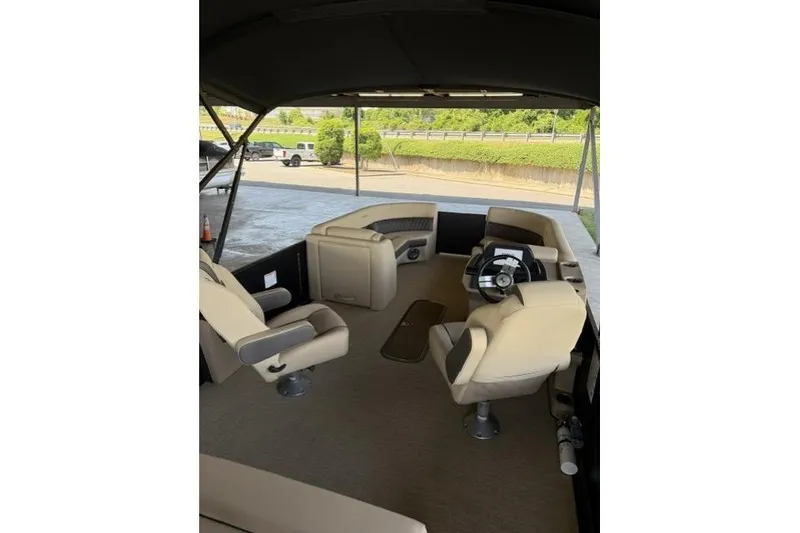 Slide: The Image of 2025 Harris Sunliner 230 boat interior with beige seating and steering wheel. - 17
