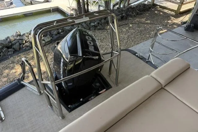 Slide: The Image of 2025 Harris Sunliner 230 boat with powerful outboard motor, docked near a serene waterfront. - 6