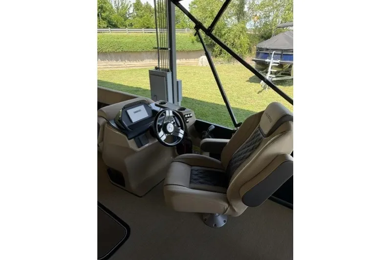 Slide: The Image of Captain's seat and helm of 2025 Harris Sunliner 230 boat, featuring modern controls and steering. - 7