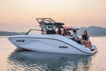 Slide: The Image of 2026 Yamaha Boats 222XE on serene water at sunset with passengers. - 3