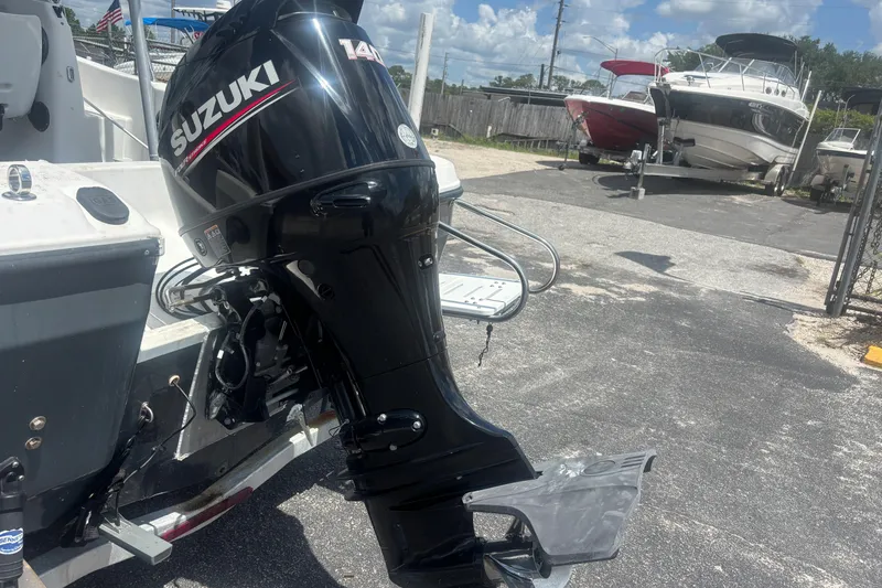 Slide: The Image of 1994 Trophy 1802 Walkaround with Suzuki 140 outboard motor in a boatyard setting. - 11