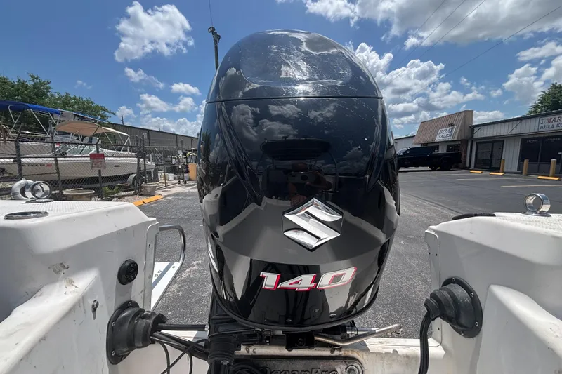 Slide: The Image of 1994 Trophy 1802 Walkaround with Suzuki 140 outboard motor in a boatyard setting. - 13