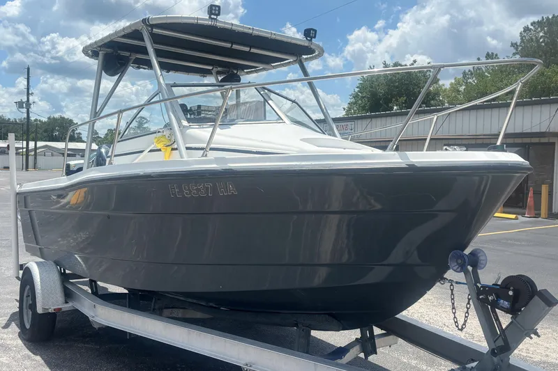 Slide: The Image of 1994 Trophy 1802 Walkaround boat on trailer under a partly cloudy sky. - 7