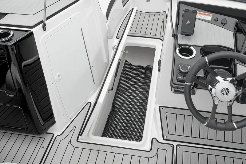 Slide: The Image of Manufacturer Provided Image: 2026 Yamaha Boats 222S interior with open storage compartment and steering wheel. - 7