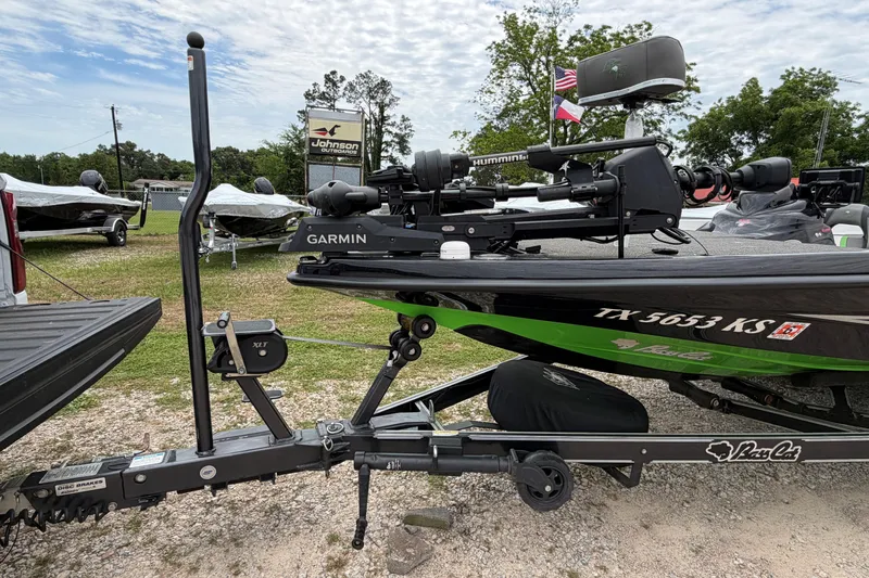 Slide: The Image of 2023 BassCat Erya boat with Garmin equipment, parked outdoors near dealership. - 2