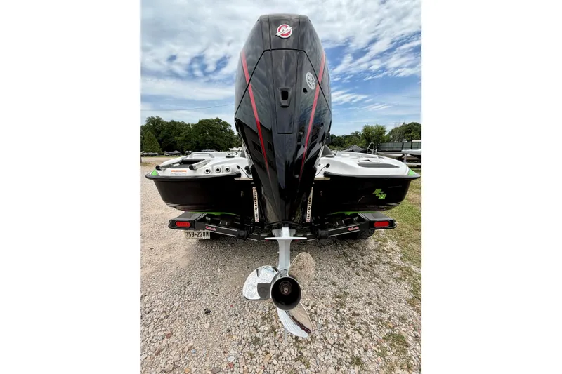 Slide: The Image of 2023 BassCat Erya boat rear view with powerful outboard motor on gravel surface. - 4