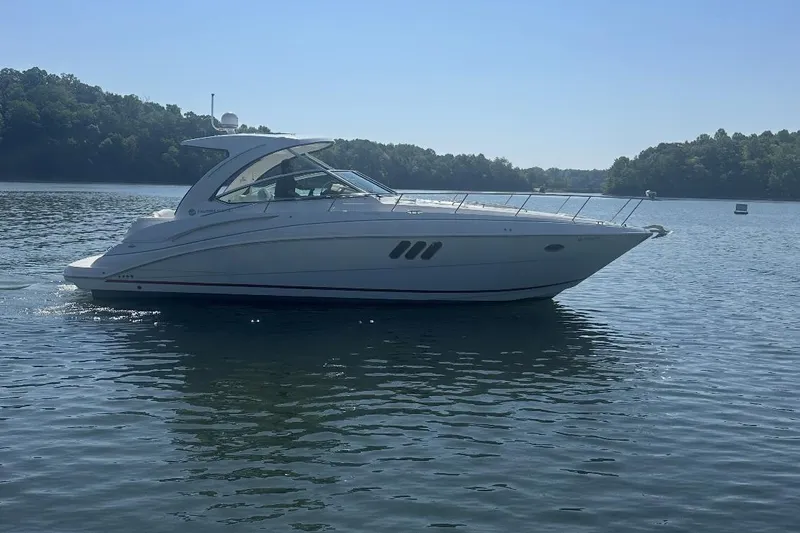 The Image of 2015 Cruisers Yachts 380 Express on a serene lake under clear skies. - 1