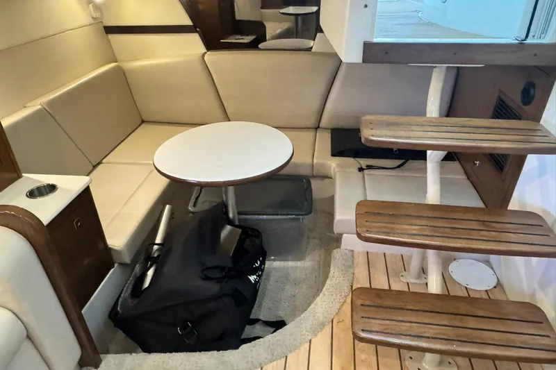Slide: The Image of Interior of 2015 Cruisers Yachts 380 Express with seating, table, and wooden steps. - 11
