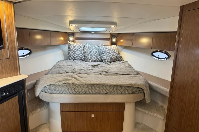 Slide: The Image of Luxurious cabin interior of 2015 Cruisers Yachts 380 Express with cozy bed and wooden cabinetry. - 13