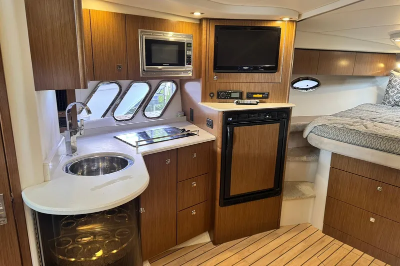 Slide: The Image of Luxurious 2015 Cruisers Yachts 380 Express interior with kitchenette and cozy sleeping area. - 14