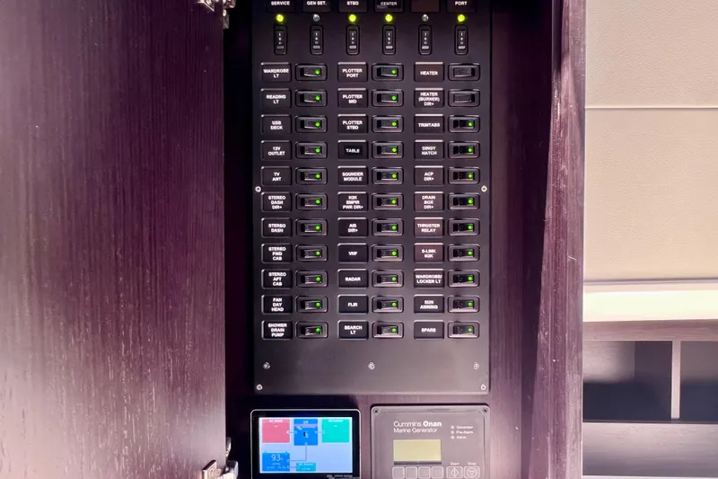 Slide: The Image of Electrical control panel inside 2022 Windy SR 44 BLACKHAWK yacht, featuring labeled switches and marine generator display. - 88
