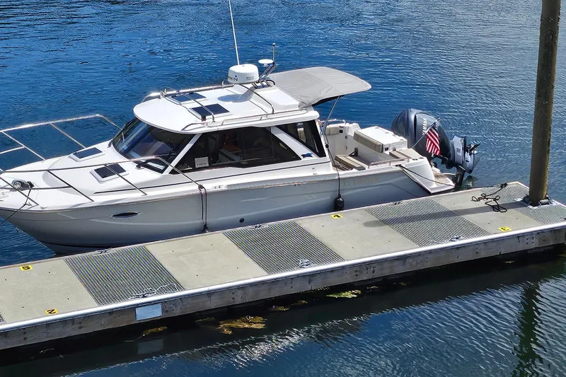 The Image of 2024 Cutwater C-248 Coupe docked on calm water, showcasing sleek design and modern features. - 1