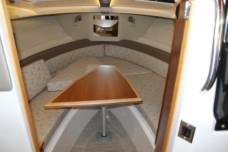 Slide: The Image of 2024 Cutwater C-248 Coupe interior cabin with cozy seating and wooden table. - 10