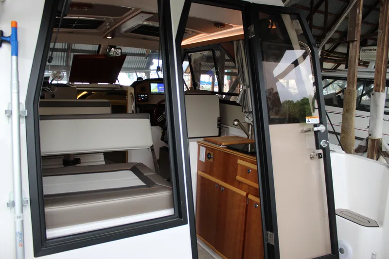 Slide: The Image of Interior view of 2024 Cutwater C-248 Coupe boat, showcasing seating and kitchenette area. - 18