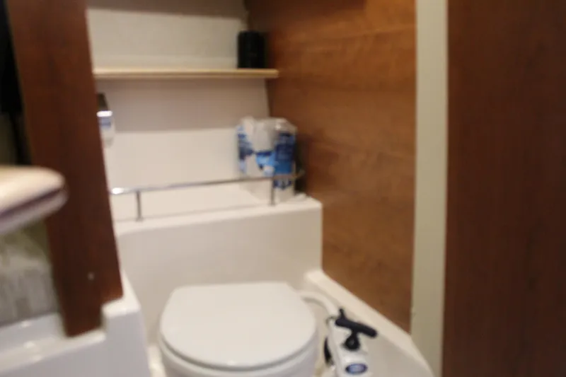 Slide: The Image of 2024 Cutwater C-248 Coupe bathroom interior with toilet and wooden accents. - 23