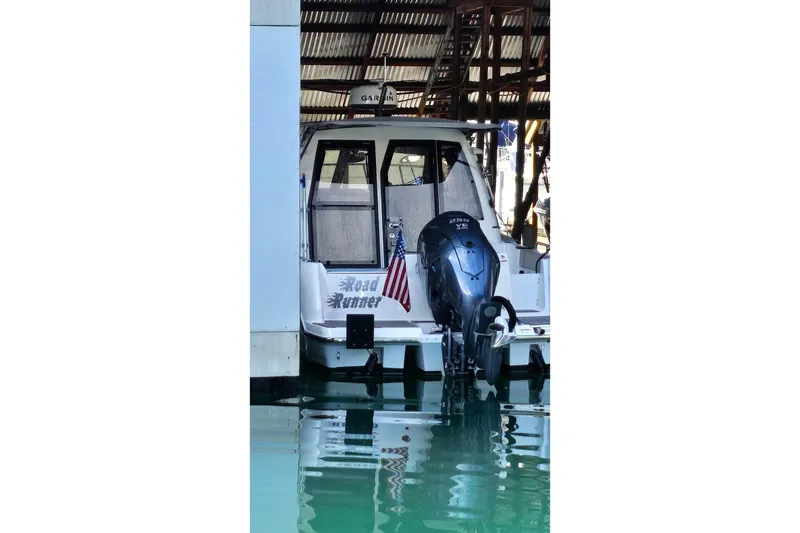 Slide: The Image of 2024 Cutwater C-248 Coupe docked, featuring a powerful outboard motor and American flag. - 3
