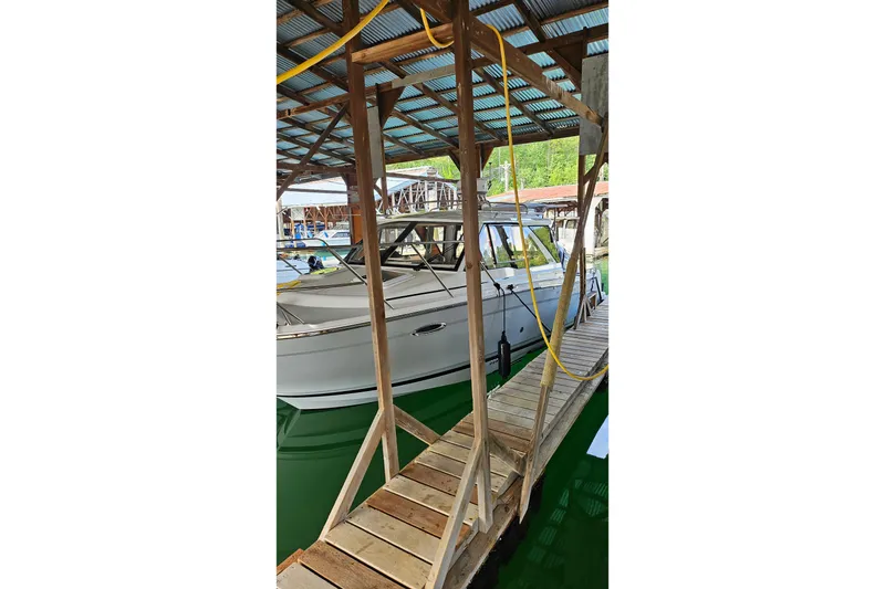 Slide: The Image of 2024 Cutwater C-248 Coupe docked under a wooden shelter. - 32